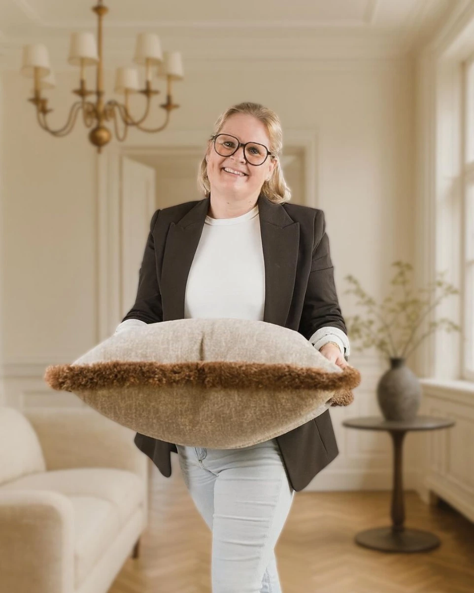 Delphine Wyseur toont een handgemaakt By DW kussen in haar interieurstudio